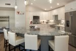 The kitchen has a granite center island with seating and modern appliances and amenities